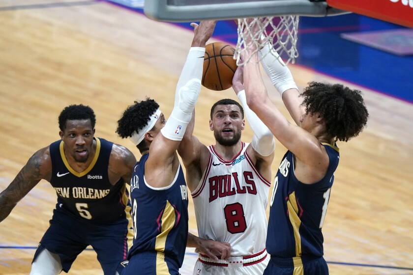 Chicago Bulls guard Zach LaVine (8) goes to the basket between New Orleans Pelicans center Jaxson Hayes, left, and guards Josh Hart and Eric Bledsoe (5) in the second half of an NBA basketball game in New Orleans, Wednesday, March 3, 2021. (AP Photo/Gerald Herbert)