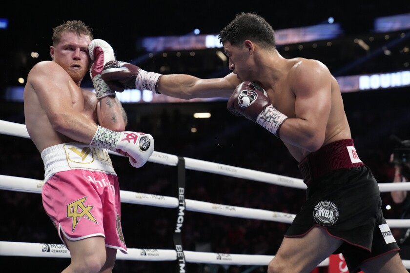 Dmitry Bivol, right, of Kyrgyzstan, throws a punch against Canelo Alvarez.