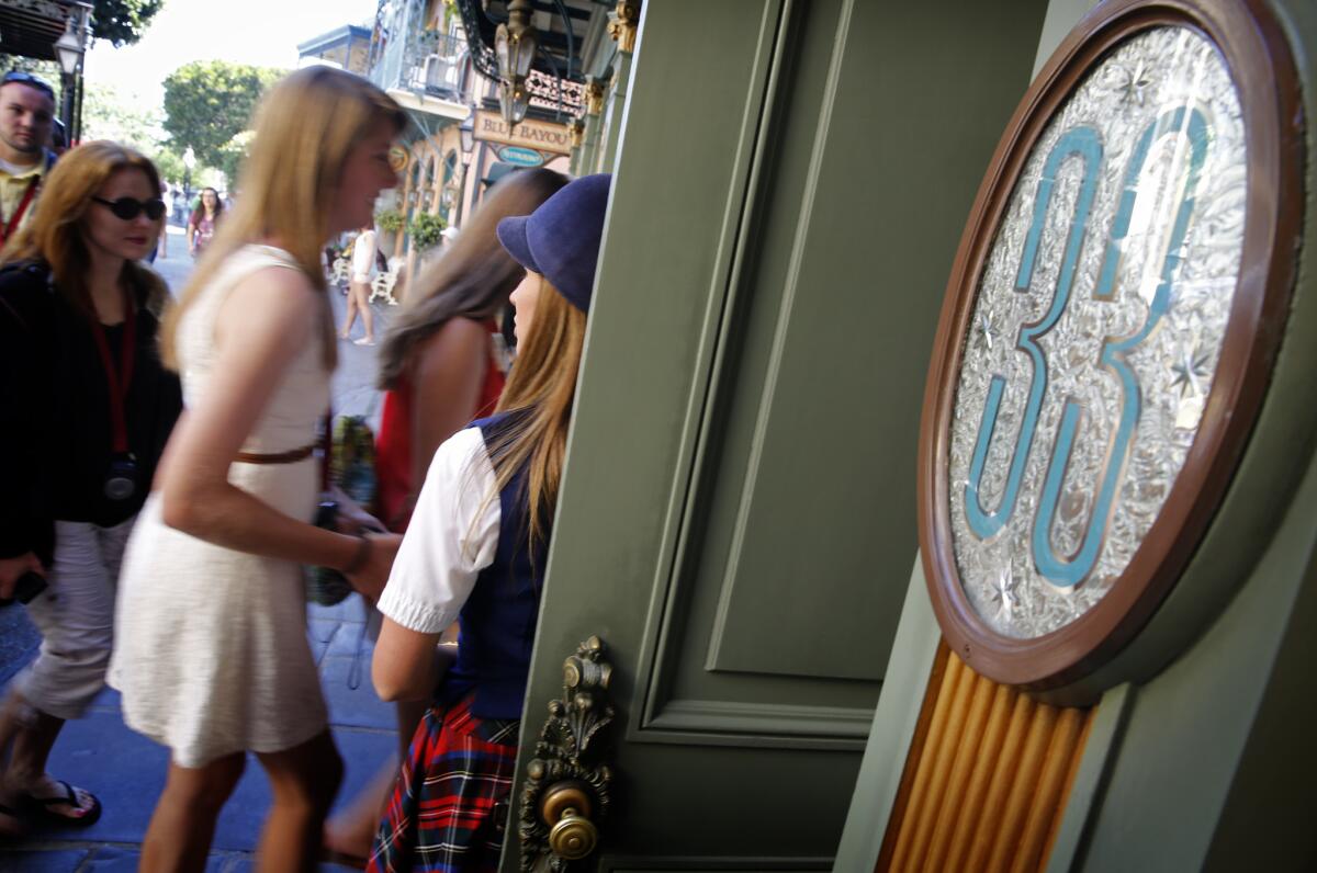 Guest relations guide Victoria Dale holds open the door to Club 33 for visitors on a special VIP tour of Disneyland in Anaheim. A former Club 33 member is suing Disneyland, claiming that his membership was unfairly revoked.