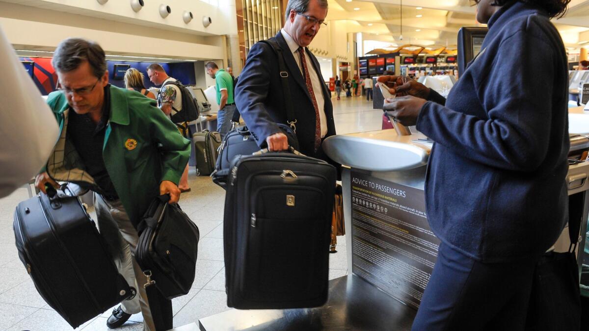 Passengers check in luggage at the Delta counter at Hartsfield-Jackson Atlanta International Airport. (John Amis / Associated Press)