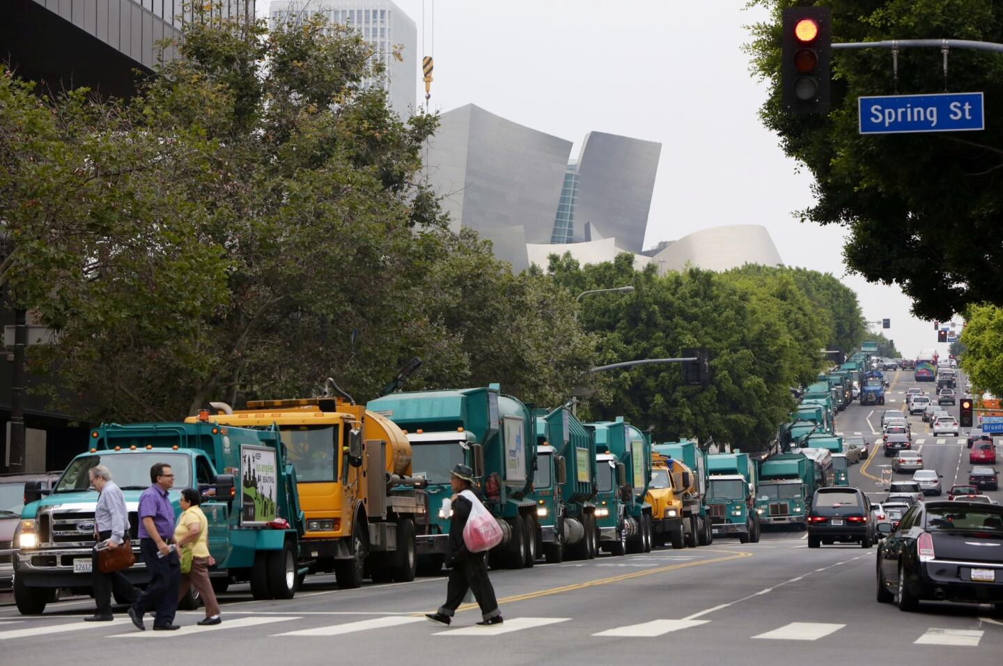Trash trucks disrupt traffic in the area of 1st and Spring streets near City Hall in downtown Los Angeles.