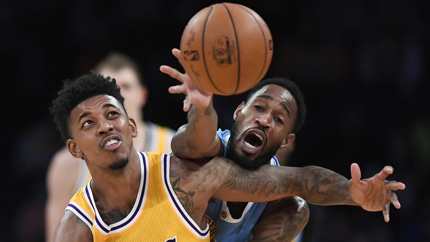 Lakers guard Nick Young, left, and Denver Nuggets guard Will Barton reach for the ball during the first half.