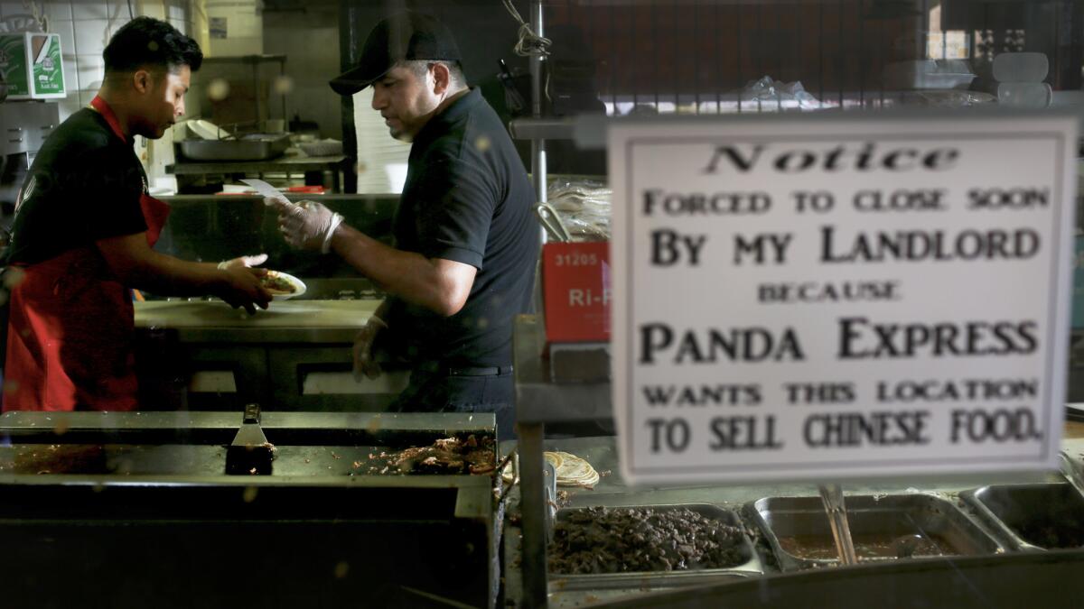 Hector Hernandez, 18, and Sebastian Montero, 30, work in the kitchen at Carnitas Michoacan.