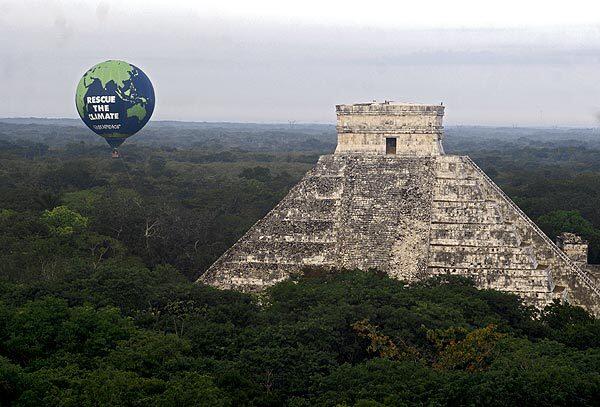 In this image released by the environmental group Greenpeace, a giant balloon rises next to the Chichen Itza ruins in Mexico's Yucatan Peninsula. Facing another year without a global agreement to curb climate change, 20,000 diplomats, scientists and activists will spend the next two weeks in Cancun, Mexico, debating how to mobilize money to cope with climbing temperatures, melting ice and rising seas. See full story