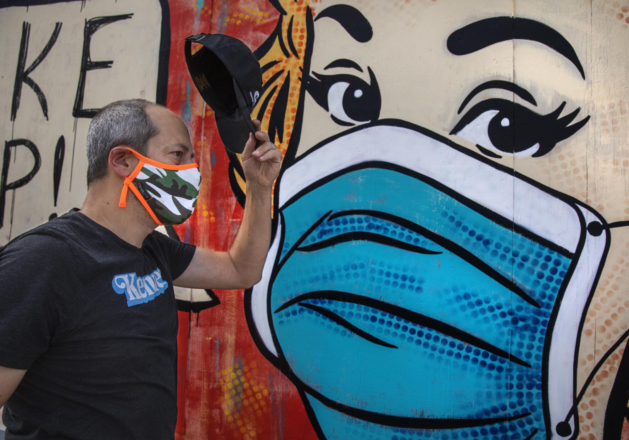 Neal Brandenburg lifts his hat to a mural created by Sara Sandoval.