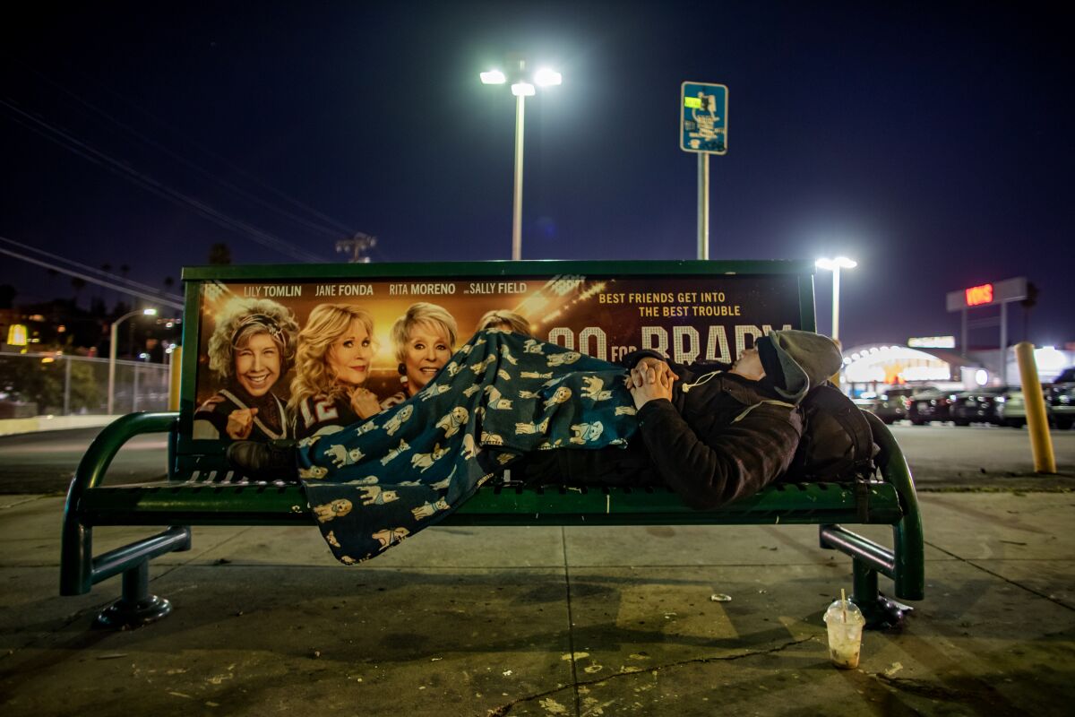 Mario Lopez sleeps on a bus stop bench in Echo Park and was counted during the 2023 Greater Los Angeles Homeless Count