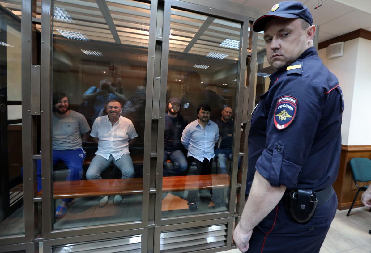 Prisoners laughing before thier setencing Monday in Moscow City Court. From left, Ibragim Makhmudov, Lom-Ali Gaytukayev, Jebrail Makhmudov, Rustam Makhmudov and Sergei Khadzhikurbanov.