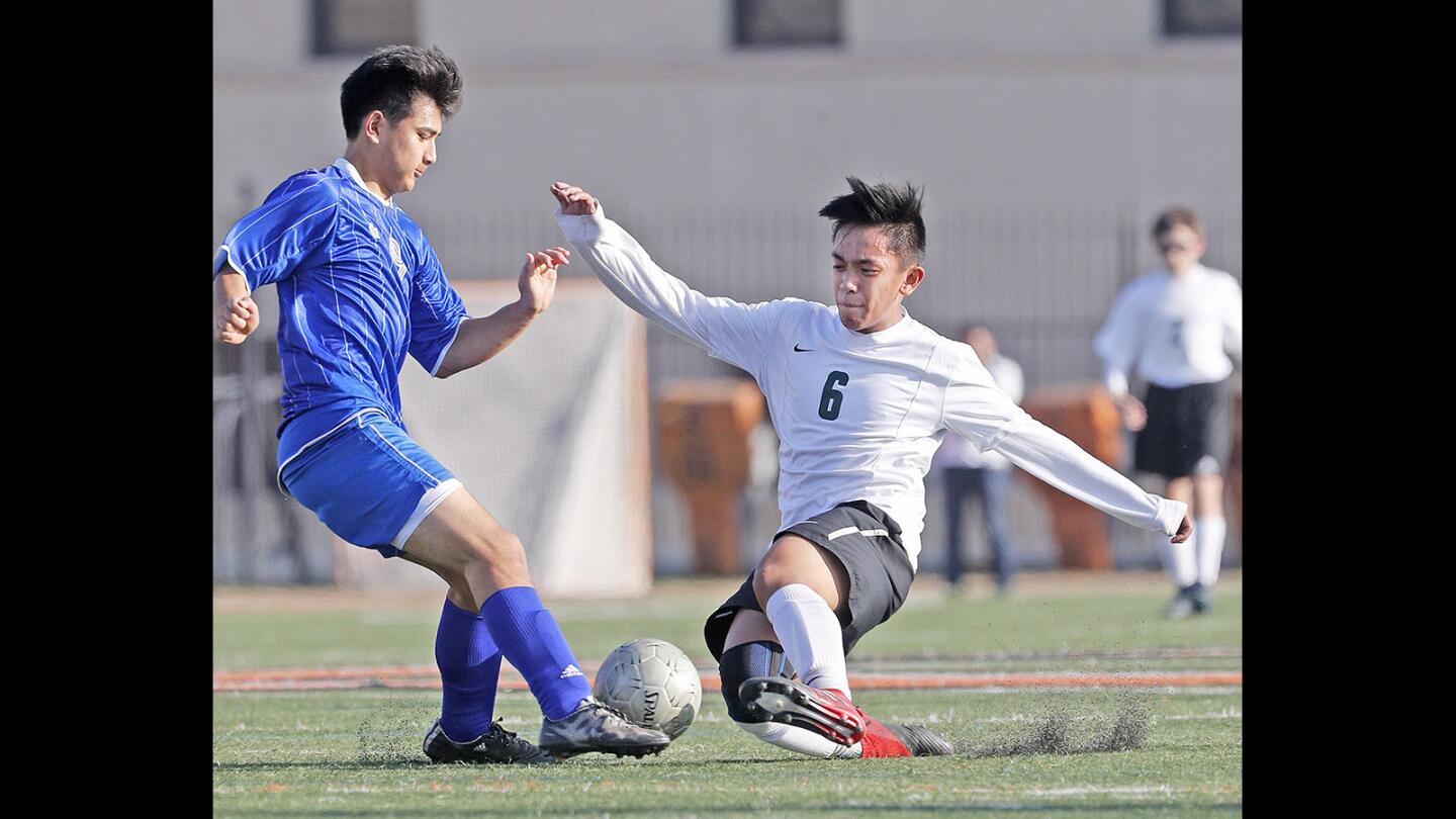 Providence's Joshua Bamba slides into the ball to pass it by Pacifica Christian's Cole Quirarte in a Independence League boys' soccer game at Occidental College in Los Angeles on Tuesday, February 6, 2018. With a win, Providence clinches first place in the Independence League. This is also the teams last game before transferring to the Prep League next year.