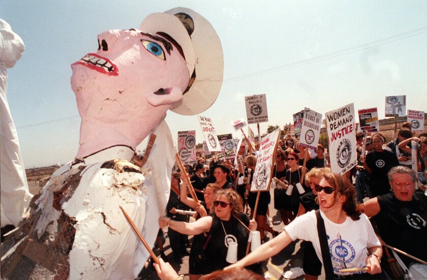 Demonstrators beat the effigy of a Navy flier while protesting sexism in the military in front of then-Naval Air Station Miramar in 1992, a year after the Tailhook scandal.