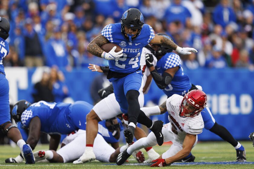 Kentucky running back Chris Rodriguez Jr. (24) evades a tackle during the first half of an NCAA college football game against Louisville in Lexington, Ky., Saturday, Nov. 26, 2022. (AP Photo/Michael Clubb)