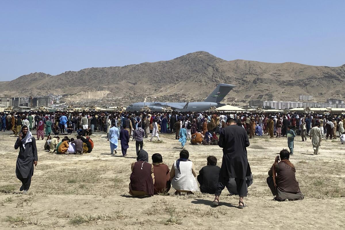 People gather near a U.S. Air Force C-17 transport plane in Kabul, Afghanistan