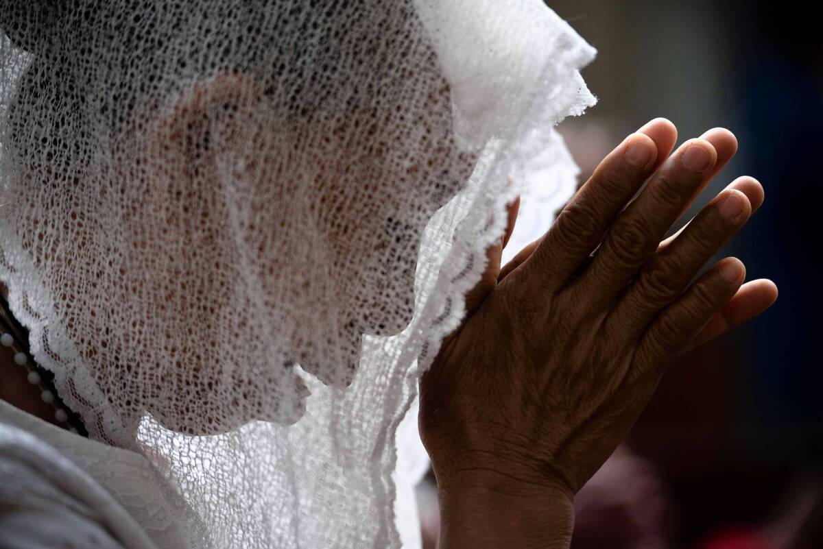 A typhoon victim prays at Santo Niño Church in Tacloban, Philippines.