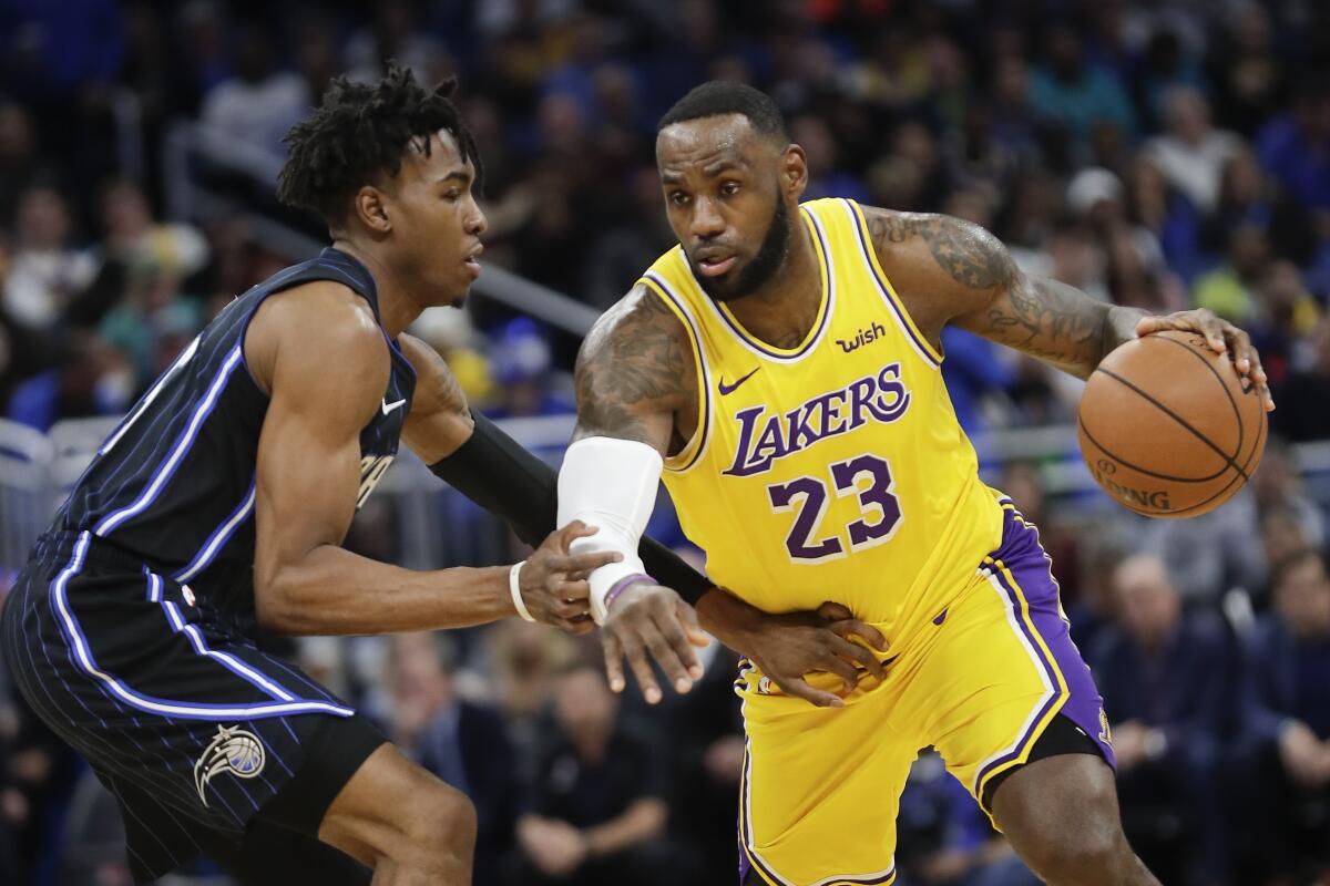 Lakers forward LeBron James drives around Magic forward Wes Iwundu during the first half of their game Dec. 11, 2019, in Orlando.