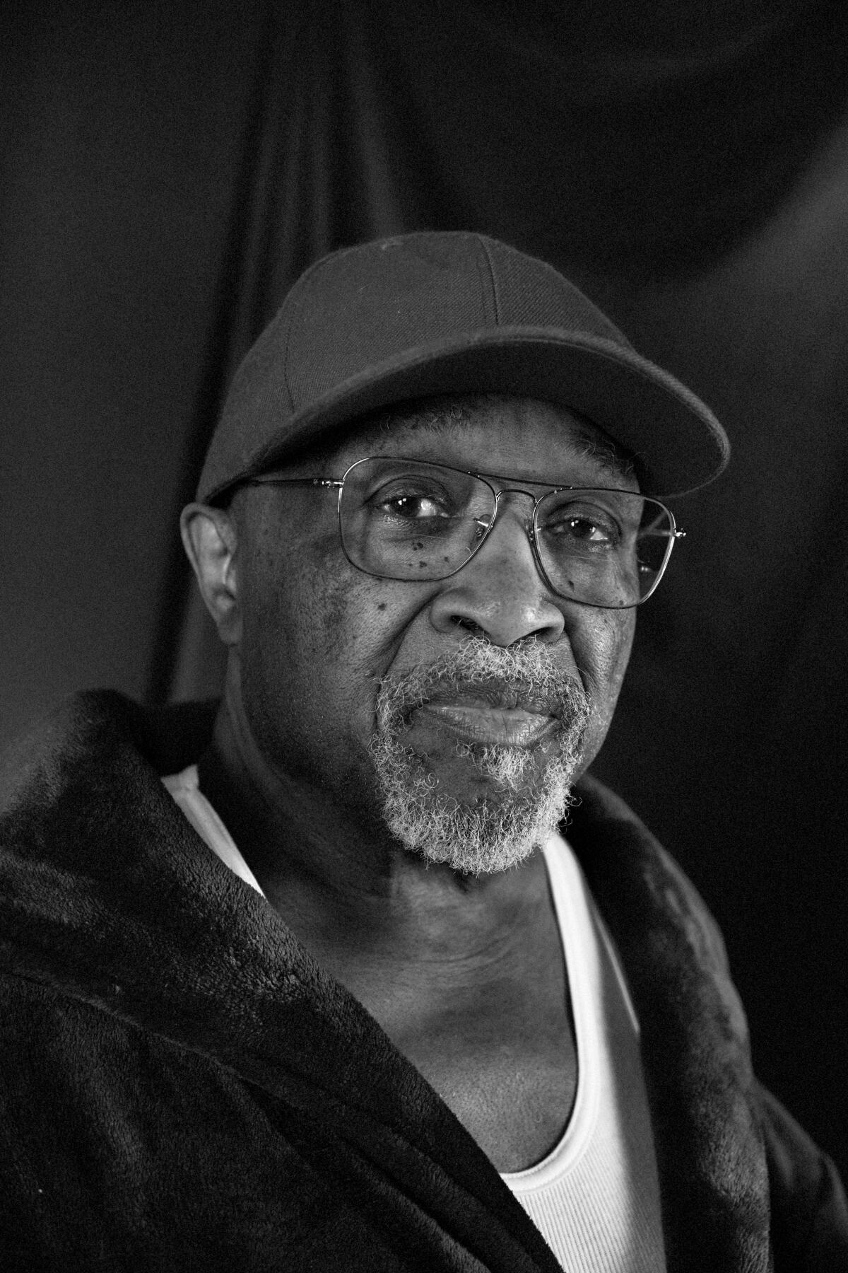 Black and white portrait of old black man in hat and glasses