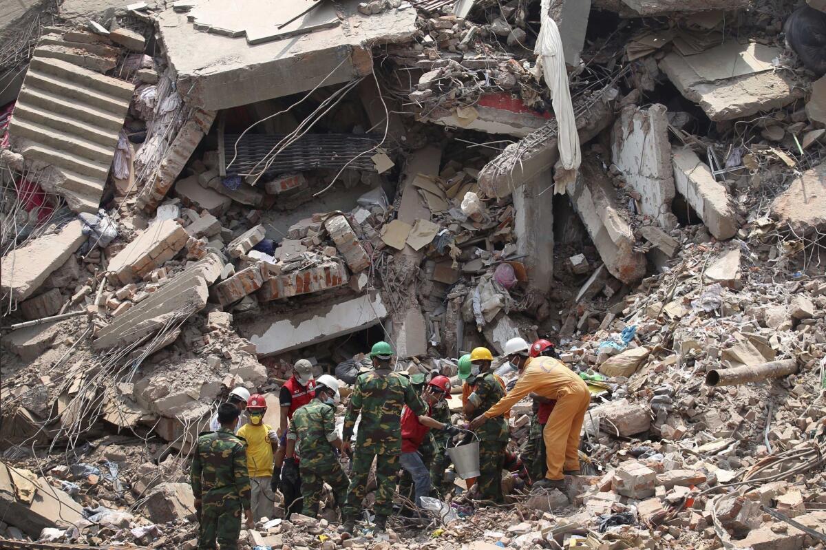 Workers try to release two bodies trapped in the rubble of the collapsed Rana Plaza garment factory building near Dhaka, Bangladesh.