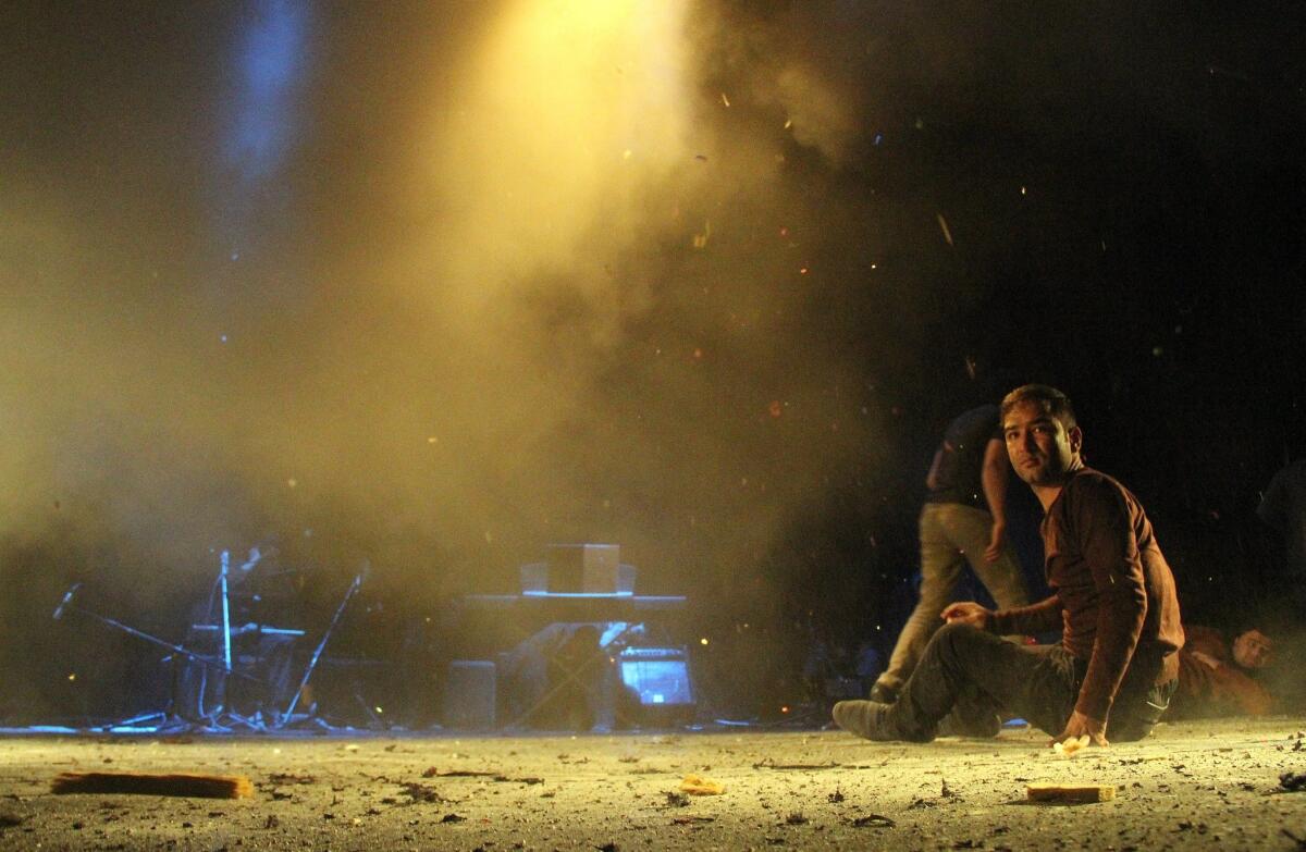 An Afghan actor sits on the ground last Thursday after a suicide attack during a performance at the French Cultural Center in Kabul, Afghanistan.