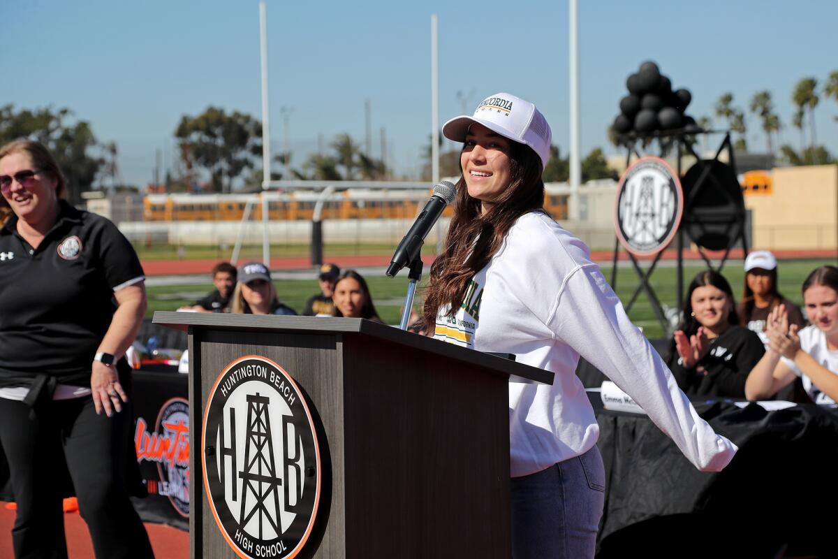 Cheerleader Kyla Daniels, right, introduces herself and what college she intends to commit to during winter signing day.