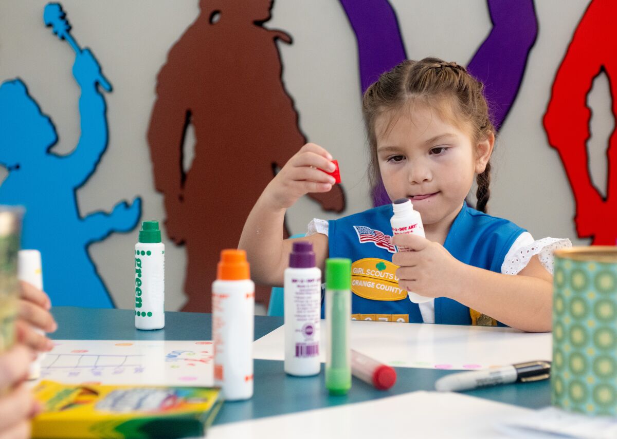 Girl Scout Mia Tejeda, 5, creates a sign to advertise cookies Friday, Jan. 20 in Newport Beach.