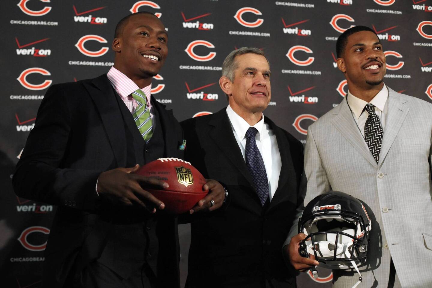 Bears GM Phil Emery poses for a portrait with two new players, Brandon Marshall and quarterback Jason Campbell on March 16, 2012.