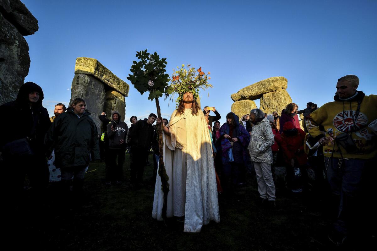 People witness the dawn of the longest day of the year at Stonehenge.