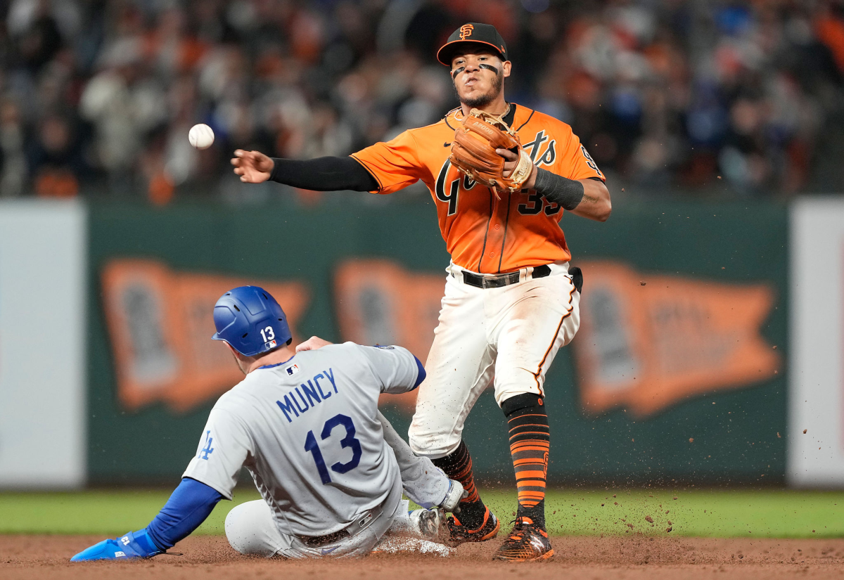 San Francisco's Thairo Estrada turns a double play in front of Dodgers baserunner Max Muncy in the sixth inning Friday.