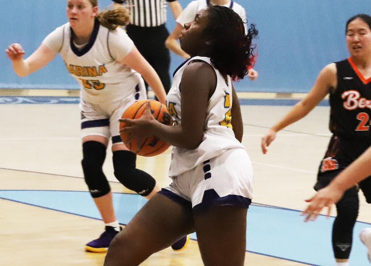 Marina High School's Rylee Bradley (23) drives to the basket against Huntington Beach.