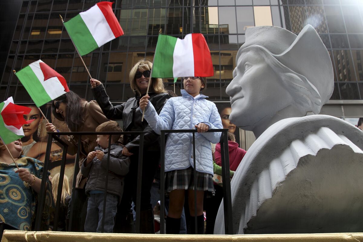 FILE - In this Oct. 8, 2012 file photo, people ride on a float with a large bust of Christopher Columbus during the Columbus Day parade in New York. Monday, Oct. 11, 2021 federal holiday dedicated to Christopher Columbus continues to divide those who view the explorer as a representative of Italian Americans’ history and those horrified by an annual tribute that ignores the native people whose lives and culture were forever changed by colonialism.(AP Photo/Seth Wenig, File)