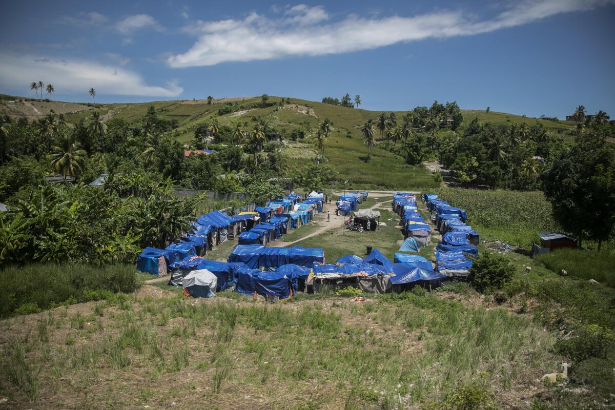 A camp of makeshift tents covered with blue tarps in Haiti.