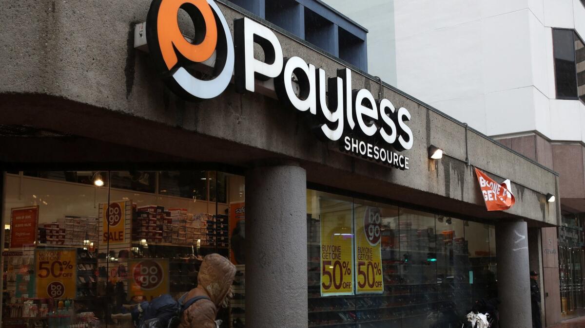 A pedestrian walks by a Payless ShoeSource store. The company is closing all of its stores in the United States and Puerto Rico.