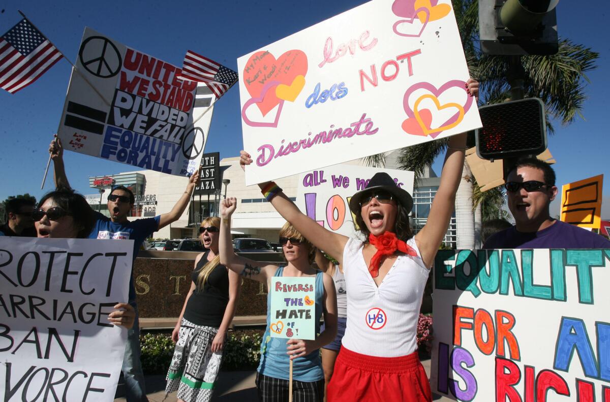 Danielle Louie, in hat, and Greg Kespradit, right, join hundreds of other opponents of Proposition 8 during a large demonstration near South Coast Plaza after the measure passed in 2008.