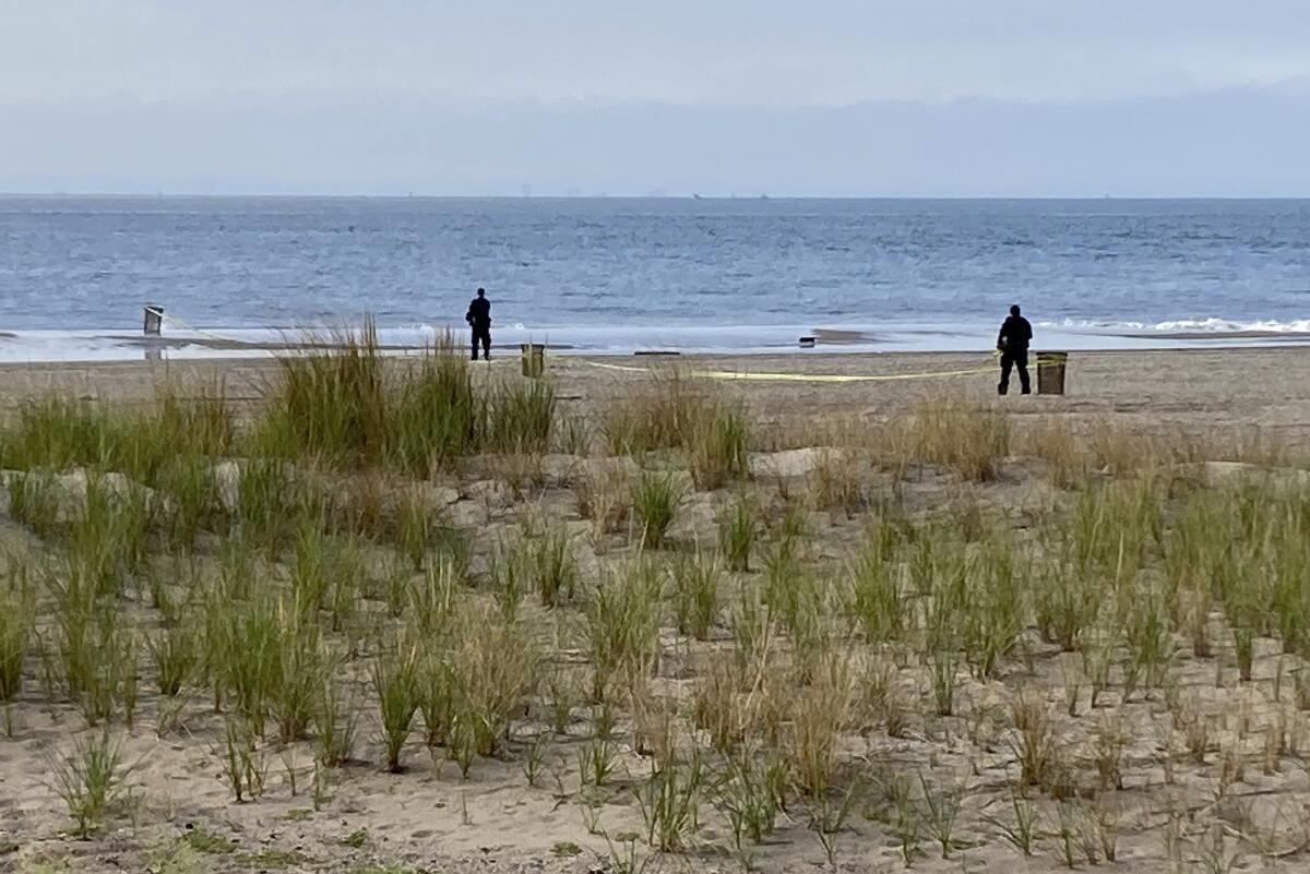 FILE - New York Police investigators examine a stretch of beach at Coney Island where three children were found dead in the surf, Monday, Sept. 12, 2022, in New York. Authorities have confirmed that the children died by drowning. (AP Photo/Joseph Frederick, File)