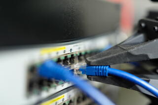Brian Gonzalez pulls an ethernet cable using a robotic arm at Encord