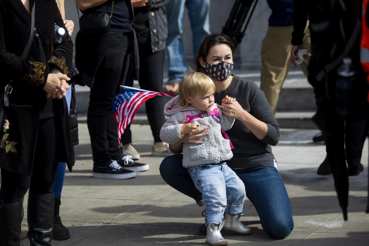 Sonia Eberhard, 36, holds her daughter Katrina Eberhard, age 2, in the celebration outside Los Angeles City Hall.