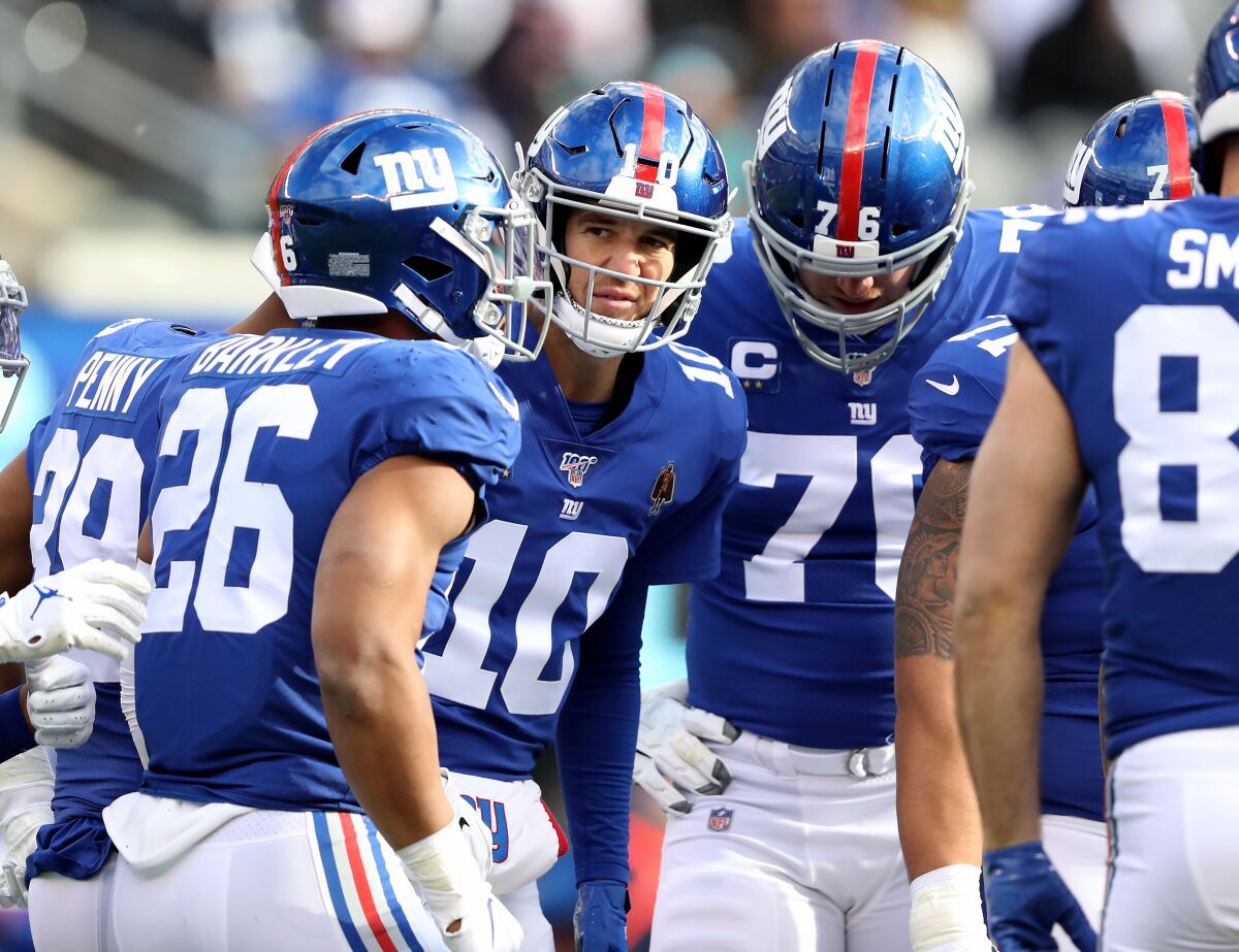 New York Giants quarterback Eli Manning huddles with his teammates during a win over the Miami Dolphins on Sunday.