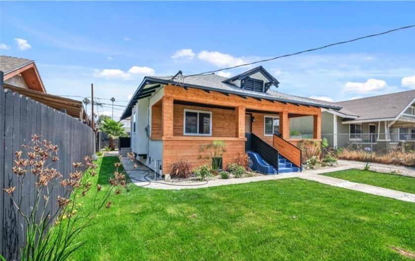 Small house with stairs and grass in front