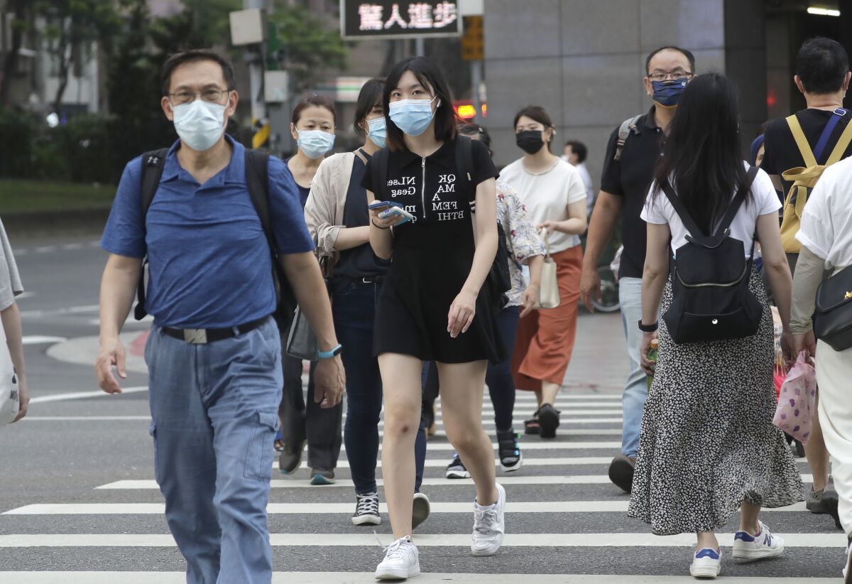 People wear face masks to help protect against the spread of the coronavirus in Taipei, Taiwan