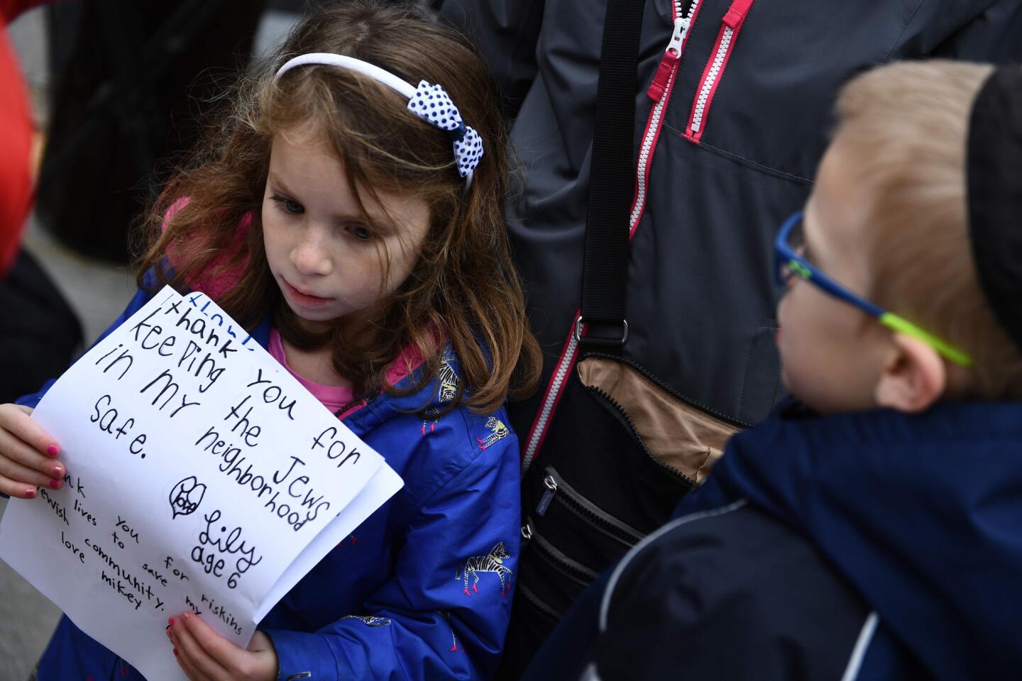 A girl holds thank you notes outside the Tree of Life synagogue in Pittsburgh on Oct. 28, 2018, after a shooting there left 11 people dead.