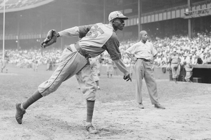 Kansas City Monarchs pitching great Leroy Satchel Paige warms up at New York's Yankee Stadium August 2, 1942 