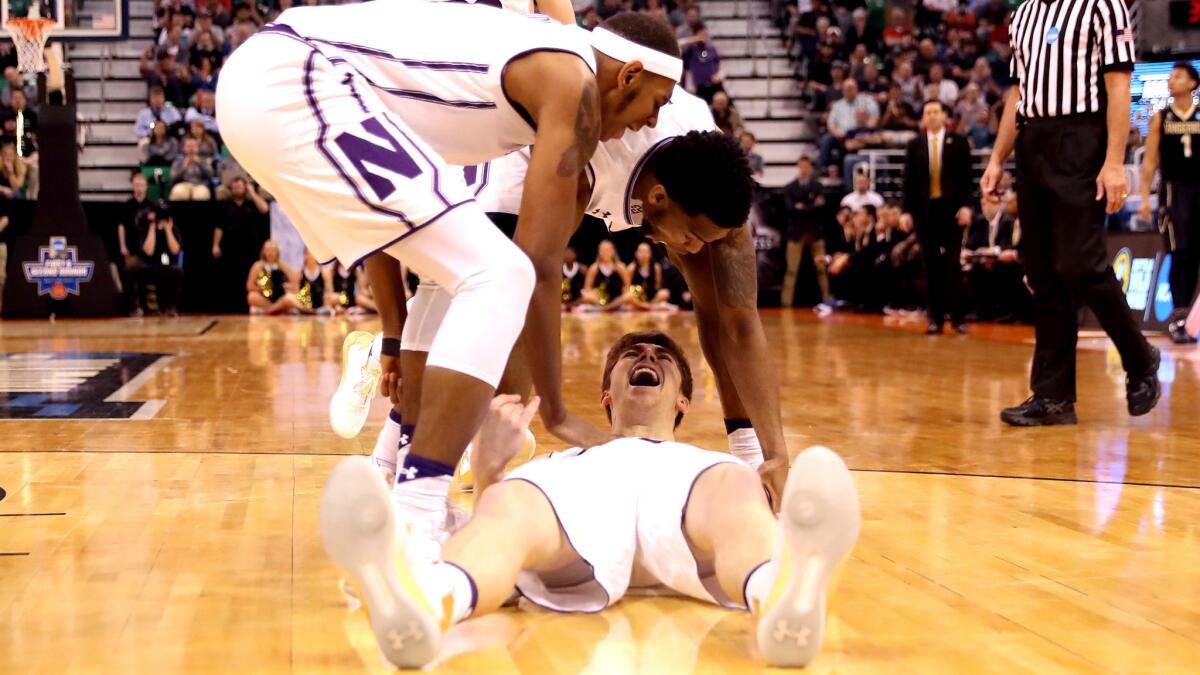 Northwestern forward Gavin Skelly celebrates with teammates as he lies on the court after drawing a foul against Vanderbilt during their game Thursday.