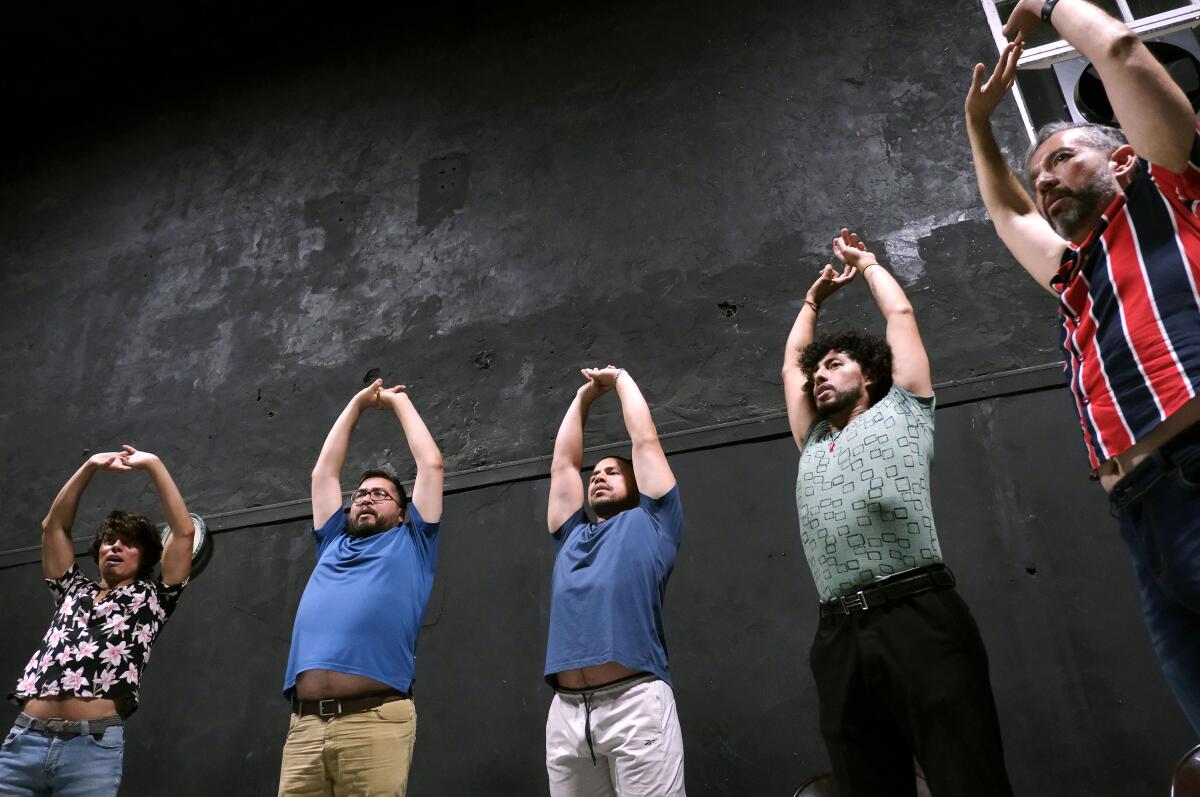 Chorus members do warm-up exercises during a rehearsal.