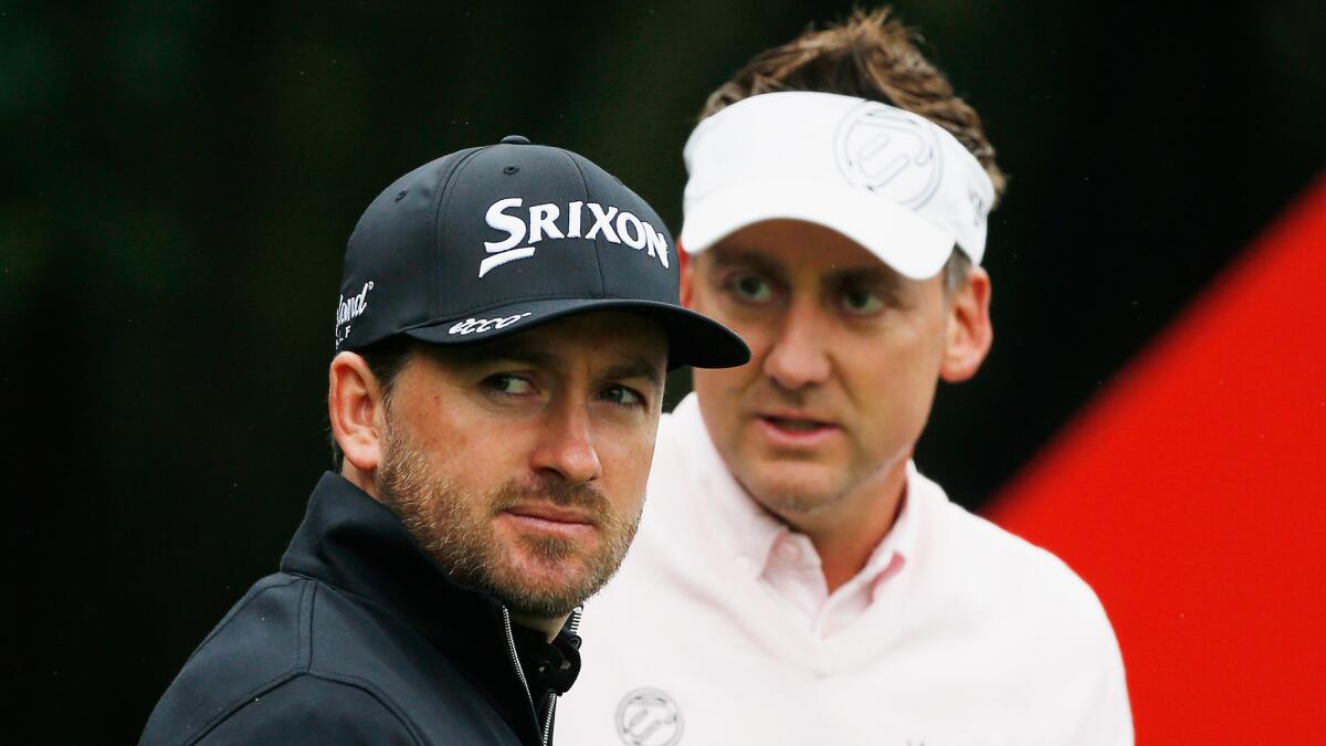 Graeme McDowell, left, and Ian Poulter wait near the fourth tee during the third round of the HSBC Champions at Sheshan International Golf Club in Shanghai on Saturday.