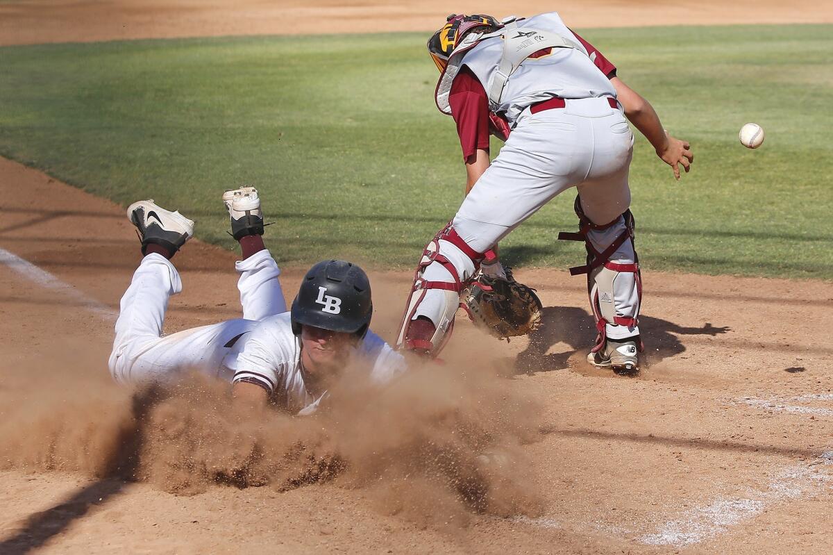 Laguna Beach High's Cutter Clawson, pictured diving across home plate safely against Estancia on May 9, 2018, helped the Breakers beat the Sailors 9-6 Wednesday.