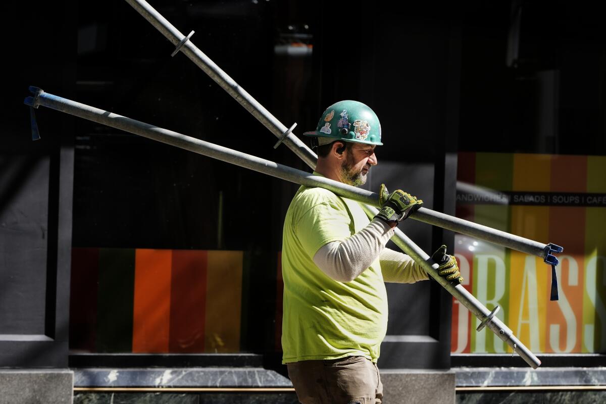 ARCHIVO - Un trabajador de la construcción realiza tareas,