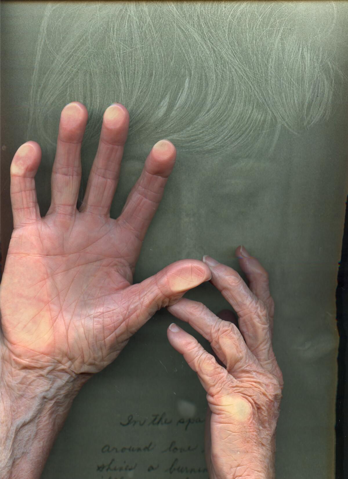 A vertical image shows the ghostly outline of aface before which are a pair of old woman's hands