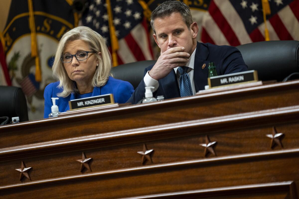 Rep. Liz Cheney and Rep. Adam Kinzinger watch a video monitor with footage from the Capitol Riot on Thursday. 
