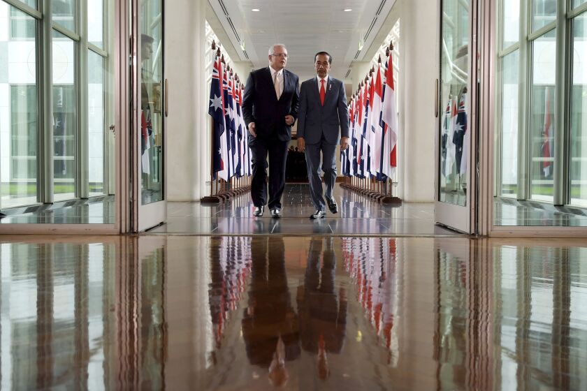 Australian Prime Minister Scott Morrison, left, walks with Indonesian President Joko Widodo through a linkway as they leave the House of Representatives at Parliament House in Canberra, Australia Monday, Feb. 10, 2020. (Tracey Nearmy/Pool Photo via AP)