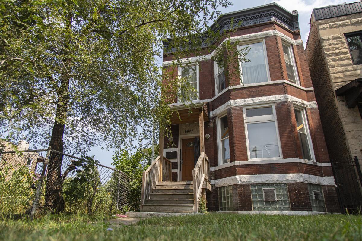 A two-story red brick Victorian house