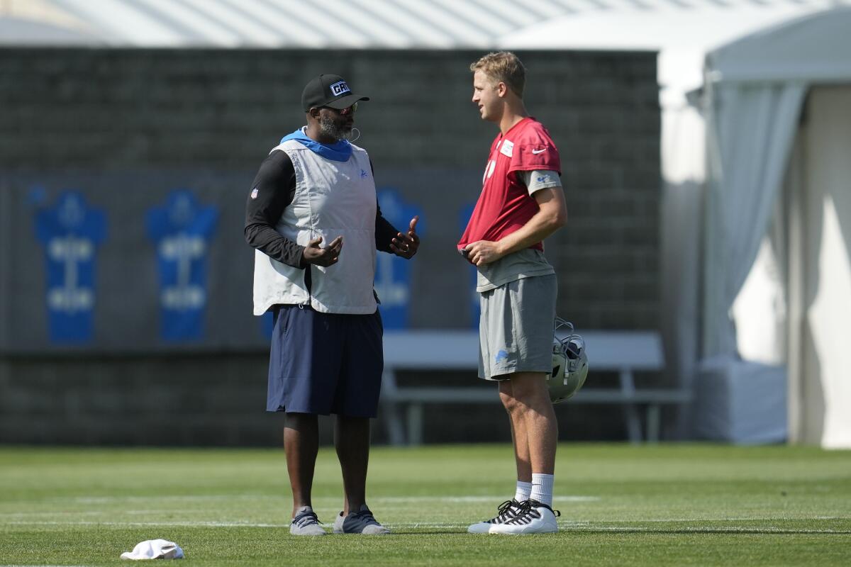 Lions general manager Brad Holmes, left, talks with quarterback Jared Goff after a preseason practice last July.