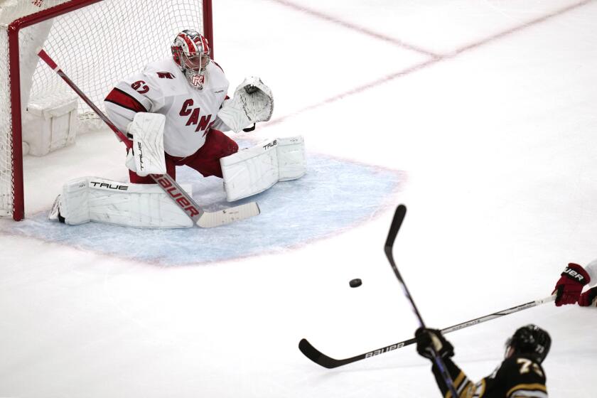 Carolina Hurricanes goaltender Pyotr Kochetkov, left, drops to his pads as Boston Bruins defenseman Charlie McAvoy (73) fires a shot for a goal during the second period of an NHL hockey game, Tuesday, April 9, 2024, in Boston. (AP Photo/Charles Krupa)