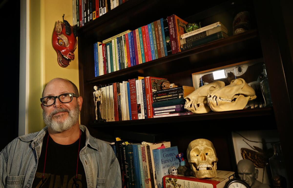 Creator of "Hellboy," Mike Mignola in his California studio, surrounded by books.
